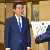名古屋市選挙管理委員会の渡辺義郎委員長（右）から当選証書を受け取る広沢一郎氏＝名古屋市中区で2024年11月25日午前10時24分、真貝恒平撮影