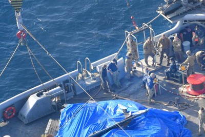 米軍のサルベージ船に引き揚げられたオスプレイの機体主要部と見られる物体＝鹿児島県・屋久島沖で2023年12月27日午後3時35分、本社ヘリから上入来尚撮影