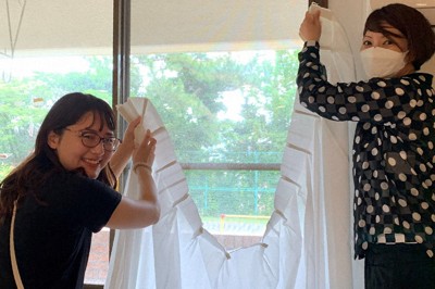 神奈川県の児童養護施設でのリフォーム支援で、室内のカーテンの取り付けを行うサンゲツ社員たち＝2024年6月、サンゲツ提供
