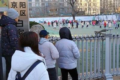 北京市内の小学校の正門前で子どもたちの下校時間を待つ保護者たち＝2024年12月5日、河津啓介撮影