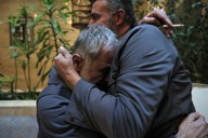 アサド政権崩壊でシリア軍情報部の拘禁施設から解放され、再会したいとこと抱き合うバッシャール・バルフームさん（左）＝シリア・ダマスカスで2024年12月12日、和田大典撮影