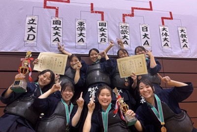 トーナメント表の前で優勝を喜ぶ園田学園女子大の選手ら＝仙台市太白区のカメイアリーナ仙台で2024年12月15日、高橋将平撮影