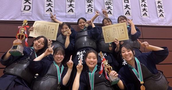 トーナメント表の前で優勝を喜ぶ園田学園女子大の選手ら＝仙台市太白区のカメイアリーナ仙台で2024年12月15日、高橋将平撮影