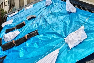 枡本実の自宅屋根。全体が壊れ、ビニールシートで応急処置をしている＝2024年4月、枡本提供