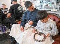 Foreign inbound tourists from Hawaii interact with a snake at Tokyo Snake Center in Tokyo's Shibuya Ward on Dec. 29, 2024. (Mainichi/Mimi Niimiya)=Click/tap photo for more images