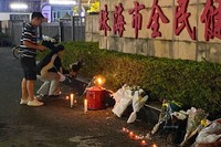車の暴走で35人が死亡した体育施設前で献花をする市民ら＝広東省珠海市で2024年11月12日