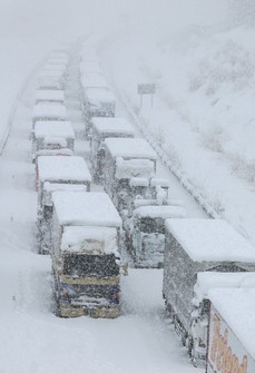 This file photo shows large vehicles stuck on the Shin-Meishin Expressway amid snowfall in the town of Komono, Mie Prefecture, on Jan. 25, 2023. (Mainichi/Koji Hyodo)