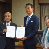 経団連の魚谷雅彦ダイバーシティ推進委員長（中央）から選択的夫婦別姓の早期導入を求める提言書を受け取った小泉龍司法相（当時）＝東京都千代田区の法務省大臣室で2024年6月28日、町野幸撮影