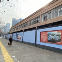 閉鎖され青い塀で囲まれた「華南海鮮卸売市場」。壁には移転先の市場の看板が掲げられていた＝中国湖北省武漢市で2025年1月18日、岡崎英遠撮影