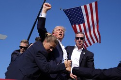 米東部ペンシルベニア州バトラーで銃撃を受けた後に拳を突き上げるトランプ氏＝2024年7月13日、AP