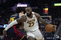 Los Angeles Lakers forward LeBron James, right, moves the ball while defended by Golden State Warriors forward Gui Santos during the first half of an NBA basketball game on Jan. 25, 2025, in San Francisco. (AP Photo/Godofredo A. Vasquez, File