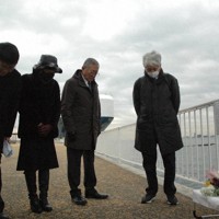 犠牲者に黙とうをささげる中田良平さん（右から2人目）ら「ダイヤモンド・プリンセス」の元乗客＝横浜市鶴見区の横浜港大黒ふ頭で2025年2月3日、岡正勝撮影