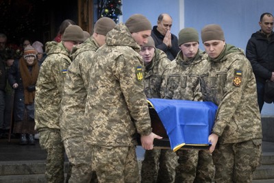 ロシアとの戦闘で死亡した仲間のひつぎを運ぶウクライナ兵＝キーウで2025年1月10日、AP