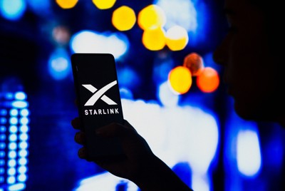スマートフォンの画面に映るスターリンクのロゴ＝ロイター
