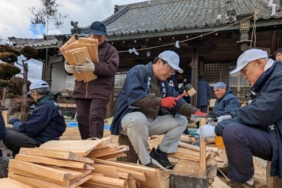 くさび形になるように鉈で板を割る参加者＝三重県名張市赤目町一ノ井で、久木田照子撮影