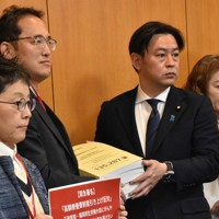 高額療養費の限度額を引き上げる政府案に反対する署名を福岡資麿厚生労働相（左から3人目）に手渡す患者団体ら＝東京都千代田区で2025年2月12日午後2時半、肥沼直寛撮影