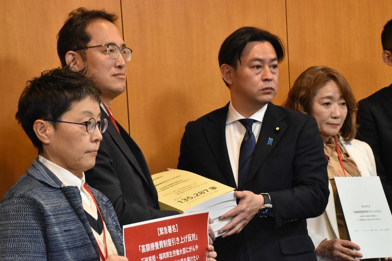 高額療養費の限度額を引き上げる政府案に反対する署名を福岡資麿厚生労働相（左から3人目）に手渡す患者団体ら＝東京都千代田区で2025年2月12日午後2時半、肥沼直寛撮影