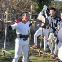 鉄パイプで作ったお手製のベンチプレス台（後方）を使って筋トレに励む部員＝さいたま市緑区の野球部グラウンドで2025年2月11日、田原拓郎撮影