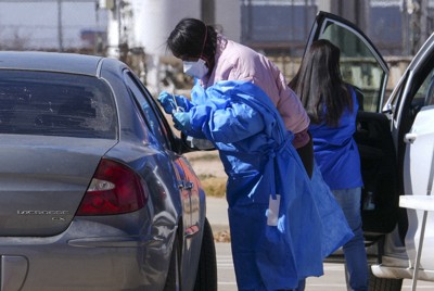 米南部テキサス州の移動検査場で、車の乗客に麻疹検査をする保健職員＝2025年2月21日、AP