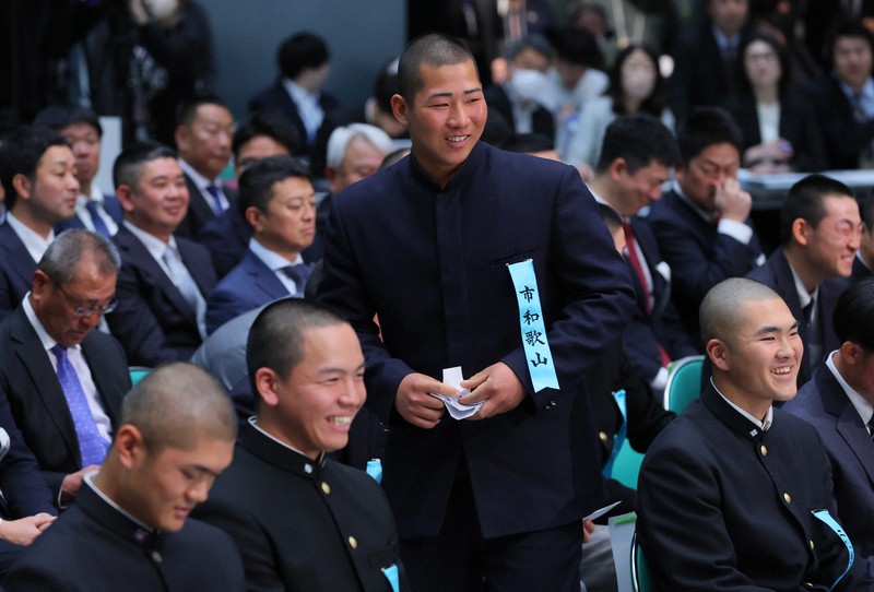 開会式で選手宣誓することが決まり、笑顔で壇上に向かう市和歌山の川辺謙信主将（中央）＝大阪市北区の毎日新聞大阪本社オーバルホールで2025年3月7日、中川祐一撮影