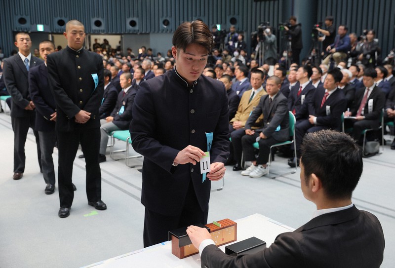 組み合わせ抽選会で札を引く青森山田の菊池伊真主将（中央）ら各校の主将たち＝大阪市北区の毎日新聞大阪本社オーバルホールで2025年3月7日、長澤凜太郎撮影