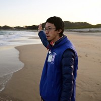 豊間海岸に立つ小野陽洋さん。海岸沿いにあった自宅で津波にのまれるも一命を取り留めた。「たまたま助かった命。意味のある活動に使いたい」＝福島県いわき市で2025年2月15日、北山夏帆撮影