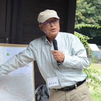 海渡神社の前で「おおくまふるさと塾」の参加者に地区の歴史を伝える鎌田清衛さん＝福島県大熊町で2024年8月10日午前10時59分、岩間理紀撮影