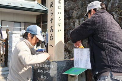 4年ぶりに更新され、両脇に新たな文言が刻まれた古学校地区の木碑＝岩手県大槌町で2025年3月10日、奥田伸一撮影