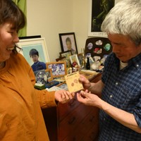 長男健太さんが残した「みらいのじぶんへ」と書かれたアサガオの種の袋を手に取る佐藤美広さん（右）と、とも子さん＝宮城県石巻市で2024年4月13日午後5時58分、百武信幸撮影