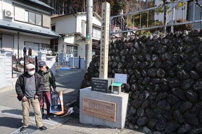 4年ぶりに更新され、新たな文言が刻まれた古学校地区の木碑の前に立つ小国忠義さん（左）＝岩手県大槌町で2025年3月10日、奥田伸一撮影