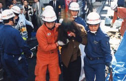 ハンカチなどで口を押さえながら、レスキュー隊員らに救出された被害者＝1995年3月20日撮影