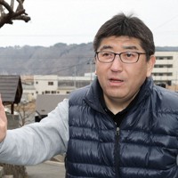 佐々木勝宏さんの両親の墓がある寺に建つ震災犠牲者の追悼碑には、父仁平さんと母妙子さんの名前が刻まれている＝岩手県宮古市田老で2025年2月17日、奥田伸一撮影