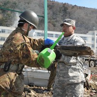 自衛隊員とガレキ撤去作業をする米軍人（右）＝宮城県石巻市で2011年4月1日午前10時すぎ、小林努撮影