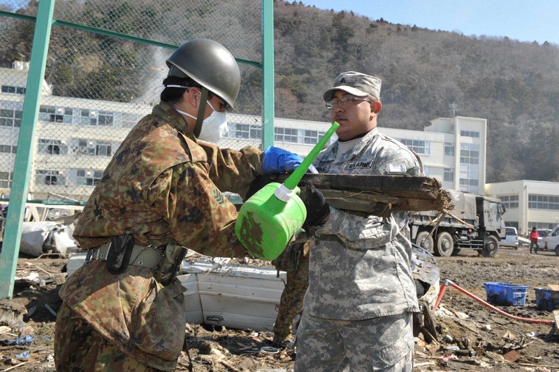 自衛隊員とガレキ撤去作業をする米軍人（右）＝宮城県石巻市で2011年4月1日午前10時すぎ、小林努撮影