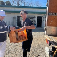 静岡でのキャンプに向けて用具をトラックに積み込む学生コーチの安藤瑞起さん（右）＝さいたま市緑区で