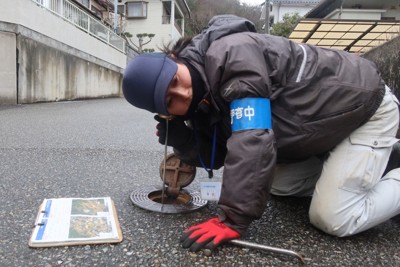 衛星調査で判明した漏水の可能性のある地点で、地中の水道管の音を聞く西播磨水道企業団の職員＝兵庫県相生市で2025年3月6日、露木陽介撮影