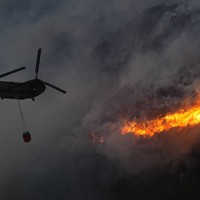 激しく燃え上がる山林火災現場で消火活動に当たる陸上自衛隊のヘリ＝岡山市南区と玉野市の境界付近で2025年3月25日午後6時6分、本社ヘリから