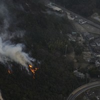 住宅地近くで燃える山林火災の現場＝岡山市南区で2025年3月25日午後6時、本社ヘリから