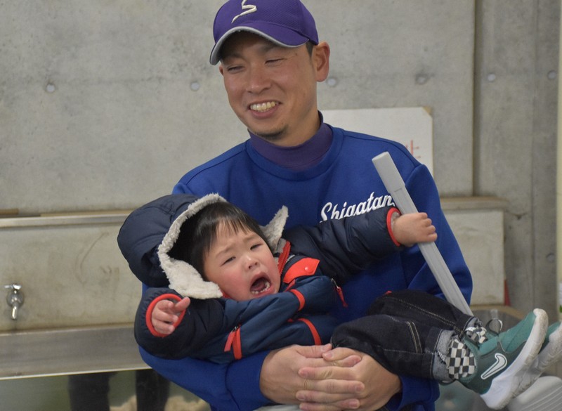 平野桂一郎部長の息子・蒼ちゃんをあやす滋賀短大付の保木淳監督＝大津市で2025年2月8日午前9時21分、吉川雄飛撮影