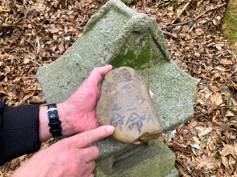 ほこらに安置されていた石には「龍蛇神」や「羅石神」などの神々の名前が書かれていた＝出雲崎町井鼻で2025年3月2日午後2時15分、中津川甫撮影