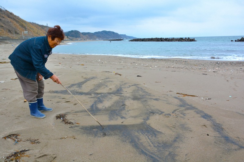 砂鉄とみられる黒い砂がまだらに広がる海辺＝出雲崎町久田で2025年3月2日午後0時22分、中津川甫撮影