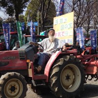 デモの先頭を引っ張るトラクターに乗った参加者＝東京都港区で2025年3月30日午後3時半、東海林智撮影