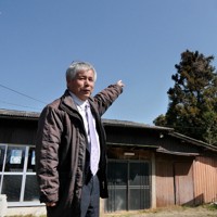 「杉の木の上あたりを飛んでいった」。自宅の庭で、2月にオスプレイを目撃した方向を指さす馬場功世さん＝熊本県菊陽町道明地区で2025年3月9日午前10時56分、中村敦茂撮影