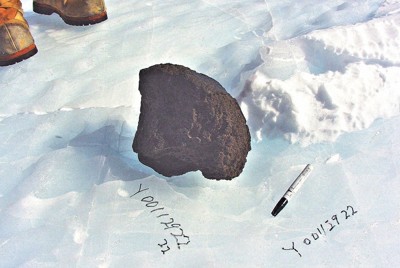 発見当時の火星の石「Yamato　000593」。発見日時などが氷の上にペンで書かれている＝国立極地研究所提供