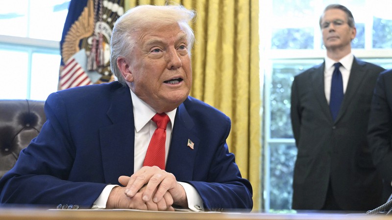 ホワイトハウスの米大統領執務室で、大統領令に署名したトランプ大統領。右はベッセント財務長官＝米ワシントンで2025年4月9日、AP