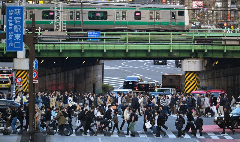 都心の交差点を行き交う人たち。追い立てられるように急ぐ人も少なくない＝東京都新宿区で9日、渡部直樹撮影