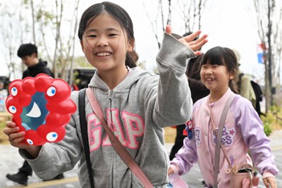 大阪・関西万博が開幕し、ミャクミャクのお面を手に笑顔で会場を回る子どもたち＝大阪市此花区で2025年4月13日午前9時22分、大西岳彦撮影