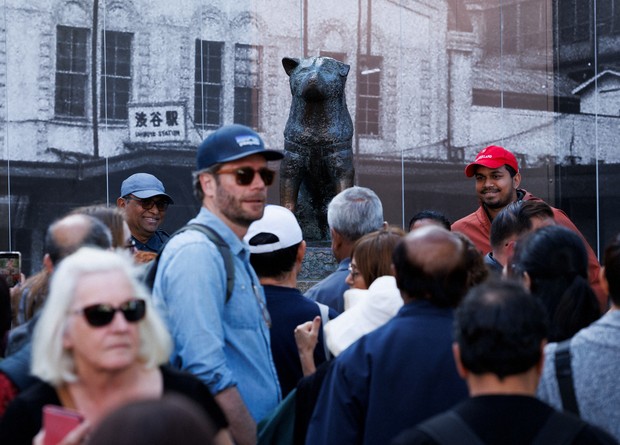 Old photo backdrop behind statue of Hachiko in Shibuya takes