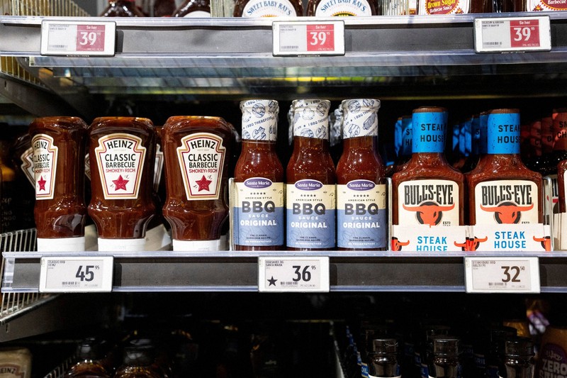 欧州の製品だと識別するために値札に黒い星のマークが付けられたバーベキューソース（中央）。両隣は米国製品＝デンマーク中部ラナースのスーパーマーケットで2025年3月17日、ロイター