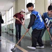 「紅白掃除合戦」で廊下を掃除する保護者と児童ら＝大阪府高槻市で2025年3月1日午前10時41分、塩路佳子撮影
